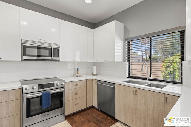 kitchen with light brown cabinets, dark wood-type flooring, sink, white cabinetry, and stainless steel appliances