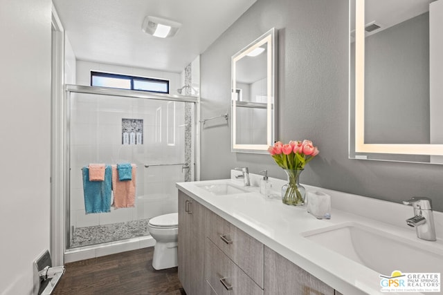 bathroom with hardwood / wood-style flooring, vanity, toilet, and an enclosed shower