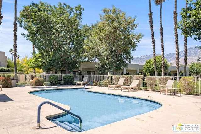 view of swimming pool with a mountain view and a patio