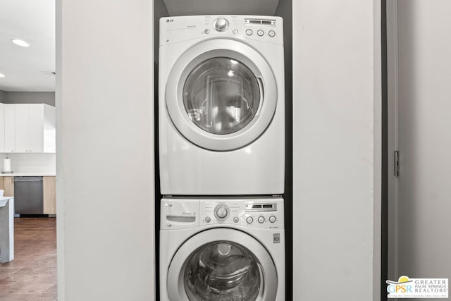 laundry room featuring stacked washing maching and dryer and wood-type flooring