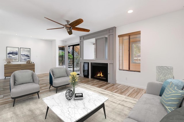 living room with ceiling fan, light hardwood / wood-style flooring, and a healthy amount of sunlight