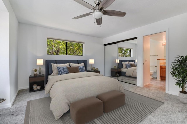 bedroom with multiple windows, light colored carpet, a closet, and ceiling fan