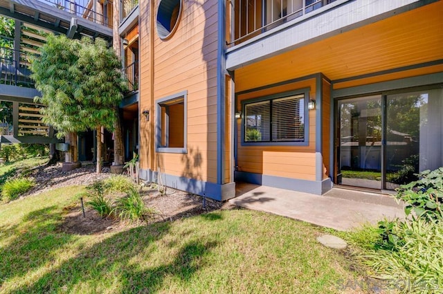 view of side of home featuring a patio and a lawn