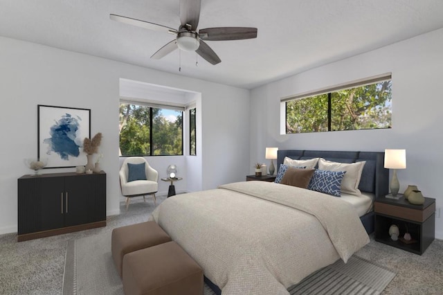 bedroom with ceiling fan, carpet floors, and multiple windows