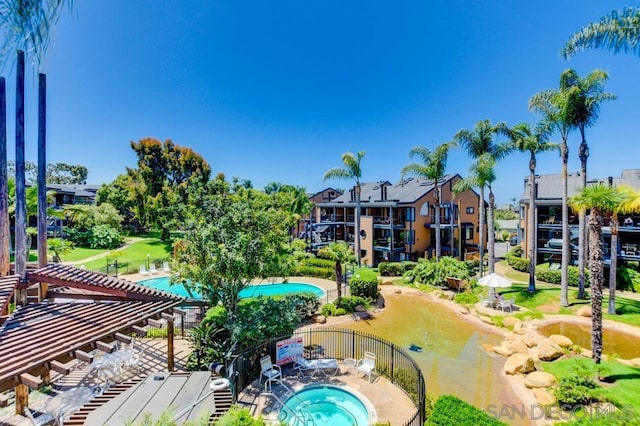 view of swimming pool featuring a pergola and a hot tub