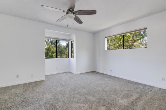 unfurnished room featuring carpet flooring, plenty of natural light, and ceiling fan