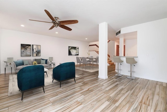 living room featuring ceiling fan and light hardwood / wood-style floors