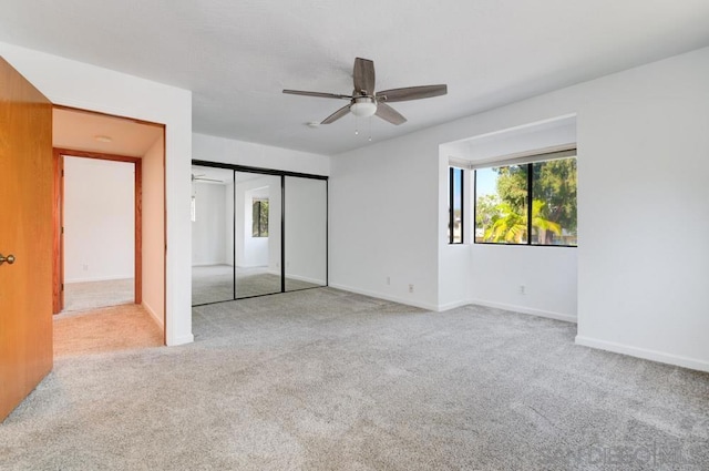 unfurnished bedroom with light carpet, a closet, and ceiling fan