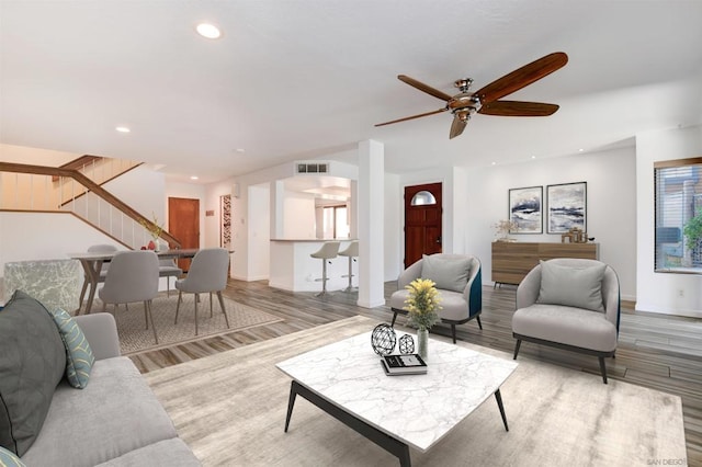 living room featuring wood-type flooring and ceiling fan