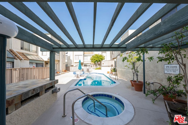 view of swimming pool featuring a community hot tub and a patio