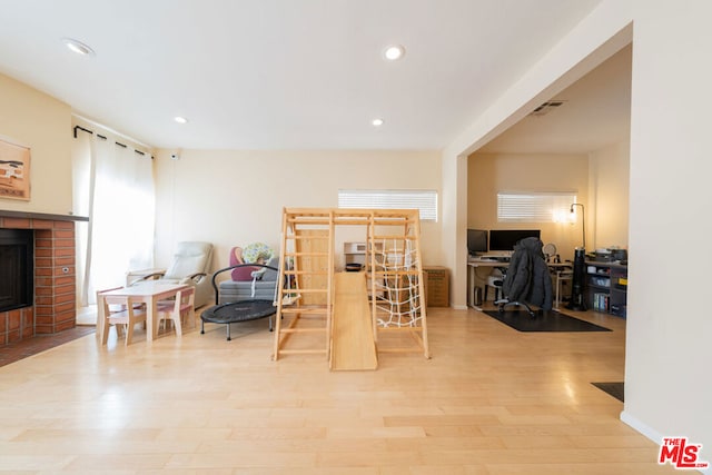 interior space featuring light wood-type flooring and a brick fireplace