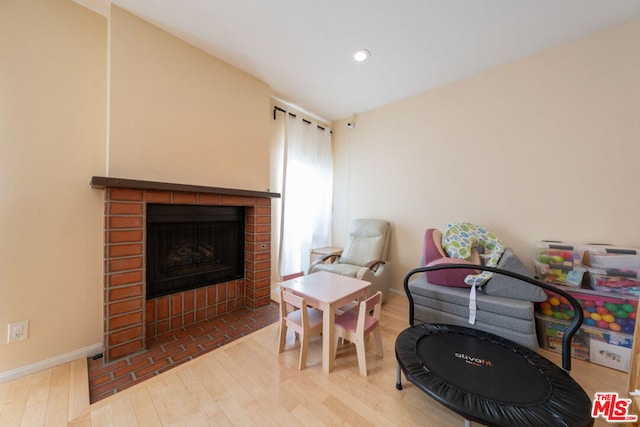 interior space with hardwood / wood-style floors and a brick fireplace