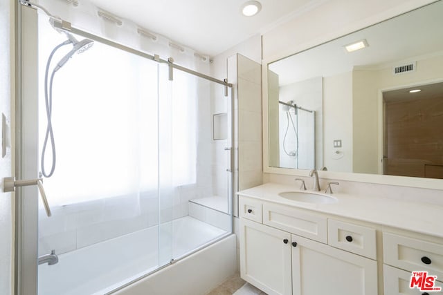 bathroom with plenty of natural light, vanity, and bath / shower combo with glass door