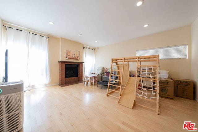 interior space featuring wood-type flooring and a brick fireplace