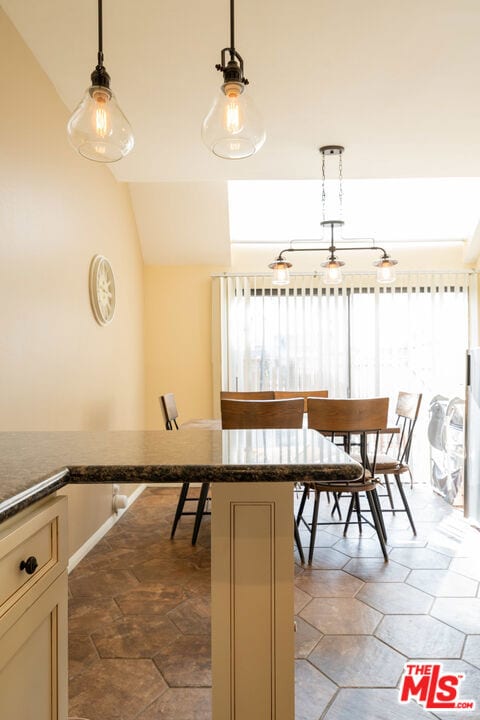 dining space with vaulted ceiling and a healthy amount of sunlight