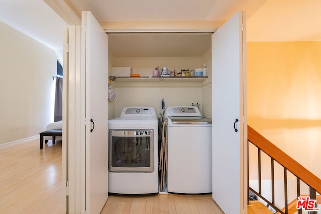 washroom featuring light hardwood / wood-style flooring and washing machine and clothes dryer