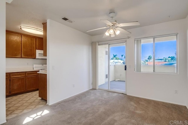 carpeted spare room featuring ceiling fan