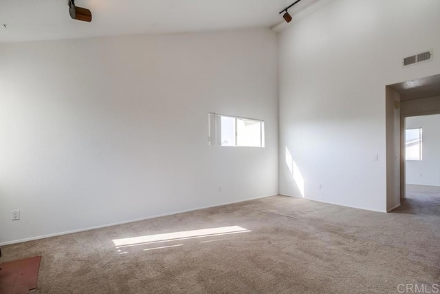 empty room featuring light colored carpet and a healthy amount of sunlight