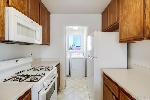 kitchen with white appliances, separate washer and dryer, light flooring, and light countertops