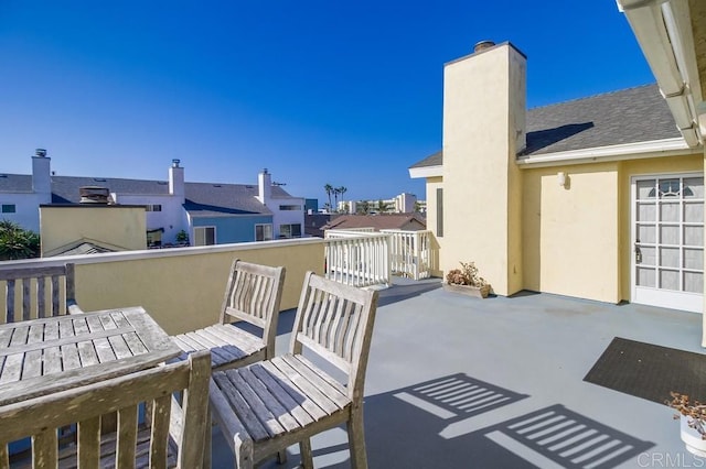 view of patio featuring outdoor dining area, a residential view, and a balcony
