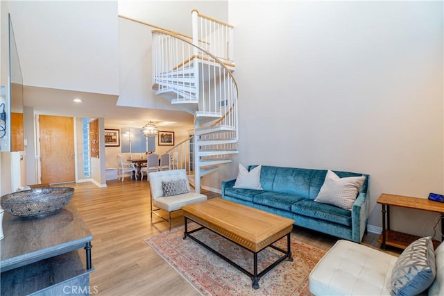 living room featuring a towering ceiling and wood-type flooring