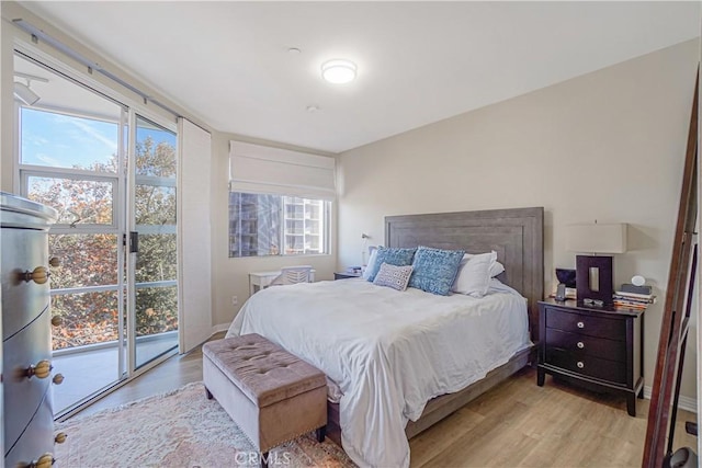 bedroom featuring access to exterior and light hardwood / wood-style flooring