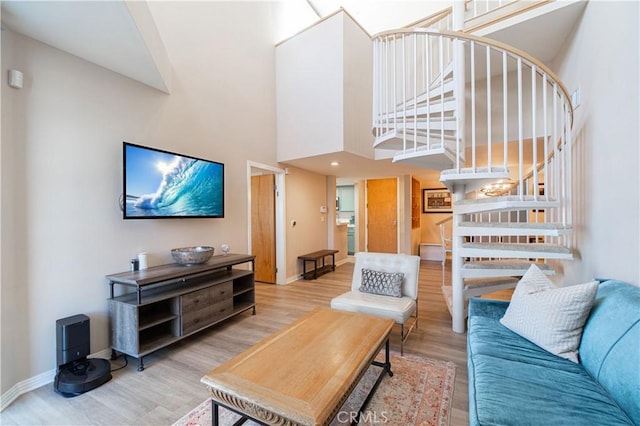 living room featuring a towering ceiling and hardwood / wood-style flooring