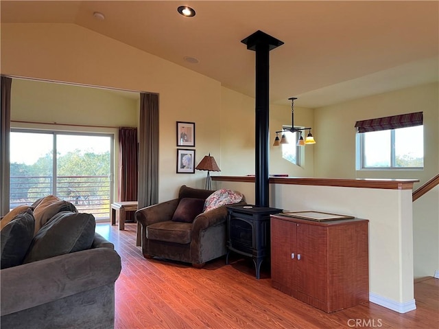 living room featuring a notable chandelier, plenty of natural light, vaulted ceiling, and hardwood / wood-style flooring