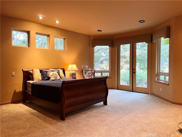 carpeted bedroom featuring access to outside, multiple windows, and french doors