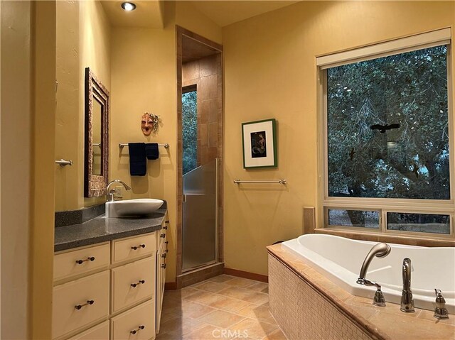 bathroom with tile patterned flooring, shower with separate bathtub, and vanity