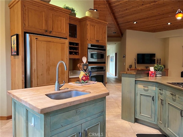 kitchen with a center island with sink, oven, wood ceiling, and sink