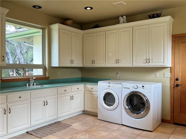 laundry area featuring cabinets, light tile patterned floors, separate washer and dryer, and sink