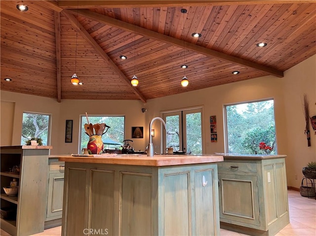 kitchen featuring an island with sink, high vaulted ceiling, and cream cabinets