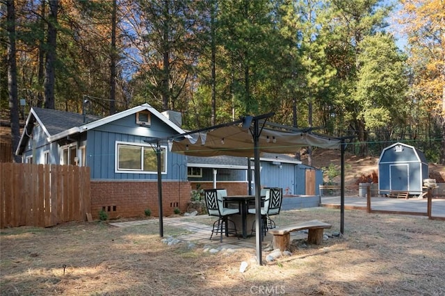 back of property featuring a patio area and a storage shed