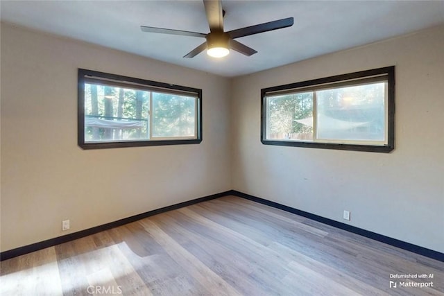 empty room with light wood-type flooring, a wealth of natural light, and ceiling fan