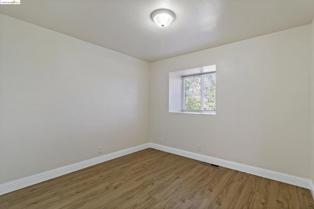 empty room with hardwood / wood-style flooring