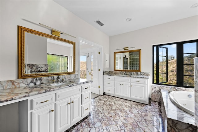 bathroom featuring tiled bath, french doors, and vanity