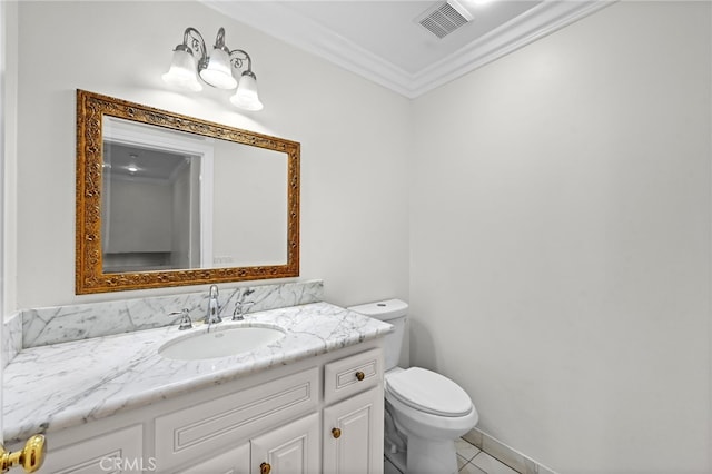 bathroom with tile patterned floors, crown molding, vanity, and toilet