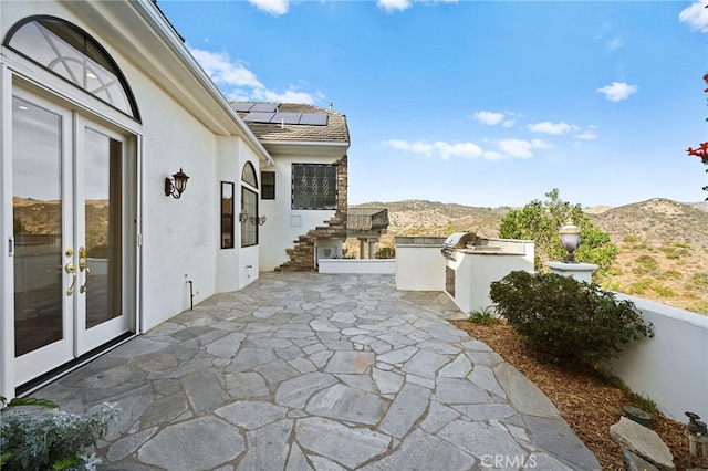 view of patio / terrace featuring a mountain view, french doors, and area for grilling