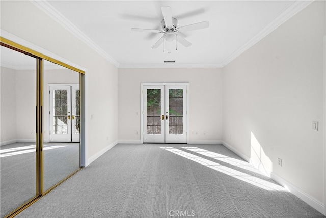 unfurnished room featuring ceiling fan, french doors, light carpet, and ornamental molding