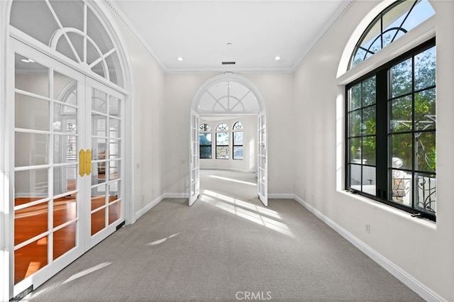 interior space featuring french doors, carpet, and ornamental molding