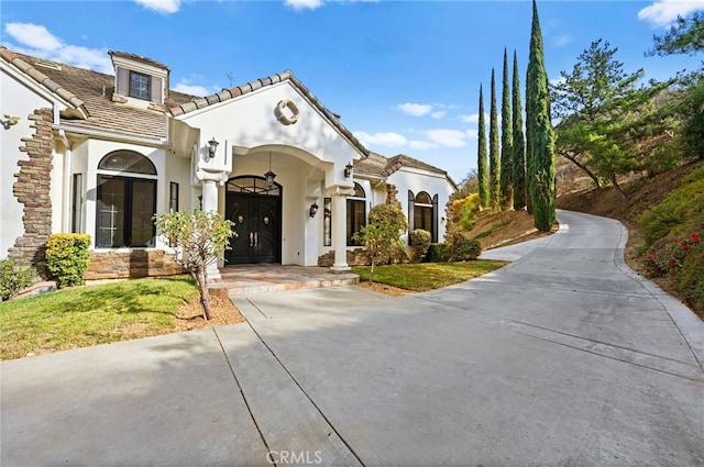 mediterranean / spanish-style house featuring a front lawn