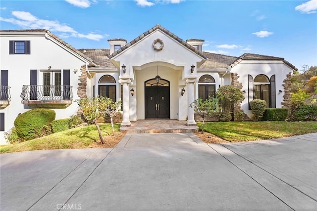 mediterranean / spanish-style house with french doors and a front lawn