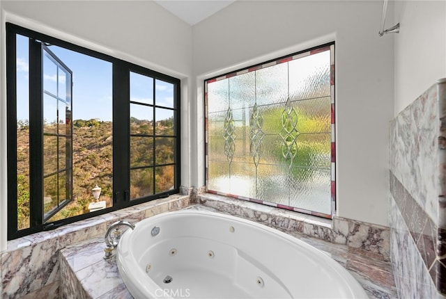 bathroom featuring plenty of natural light and tiled tub