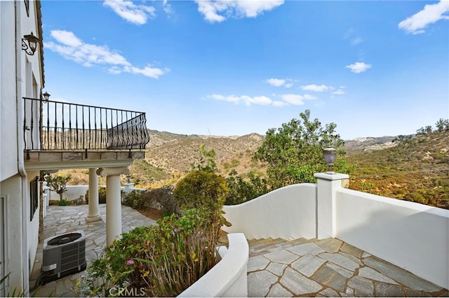 view of patio / terrace with a mountain view, a balcony, and cooling unit