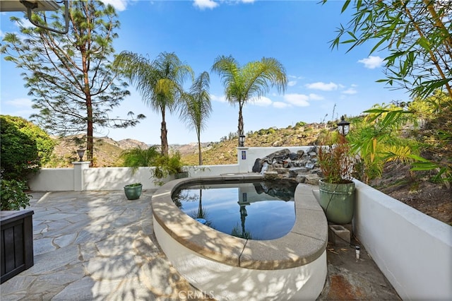 view of pool with a patio area and a mountain view