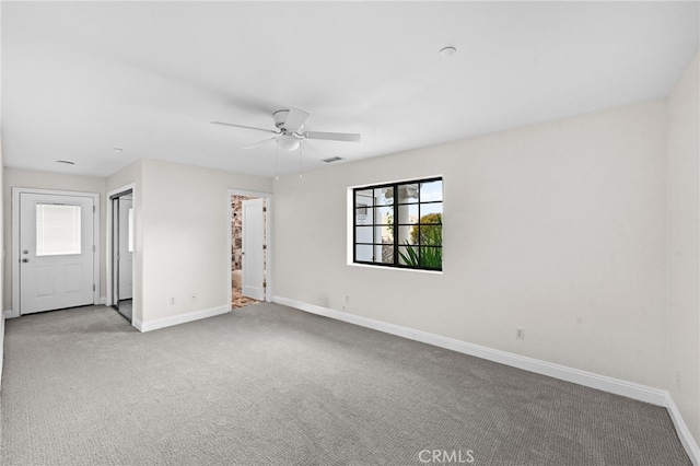 empty room featuring light colored carpet and ceiling fan