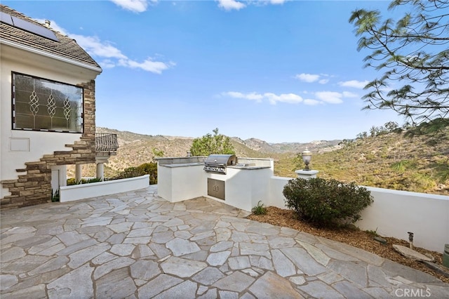 view of patio with a mountain view, area for grilling, and grilling area