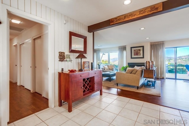 hallway with light hardwood / wood-style flooring and beamed ceiling