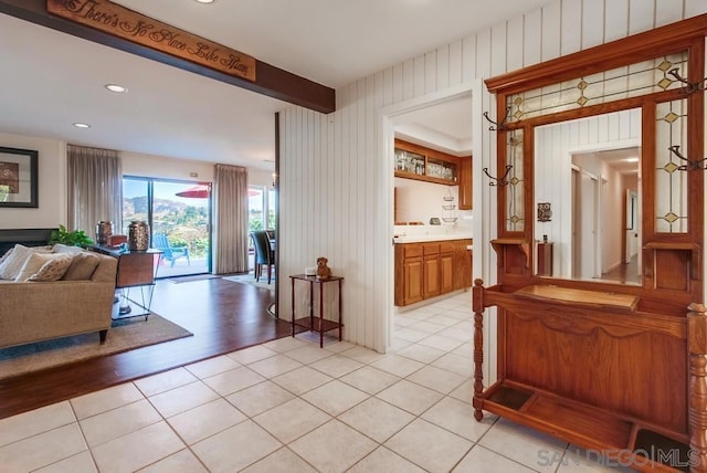 hall featuring beam ceiling and light hardwood / wood-style flooring